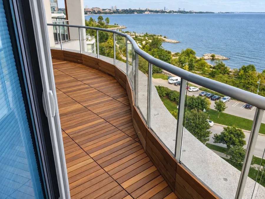 Curved terrace finished with Ipe tile decking and a glass railing.