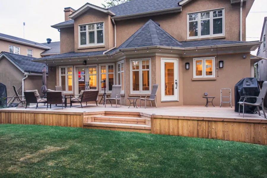 Completed wood deck with broad stairs opening onto a lawn