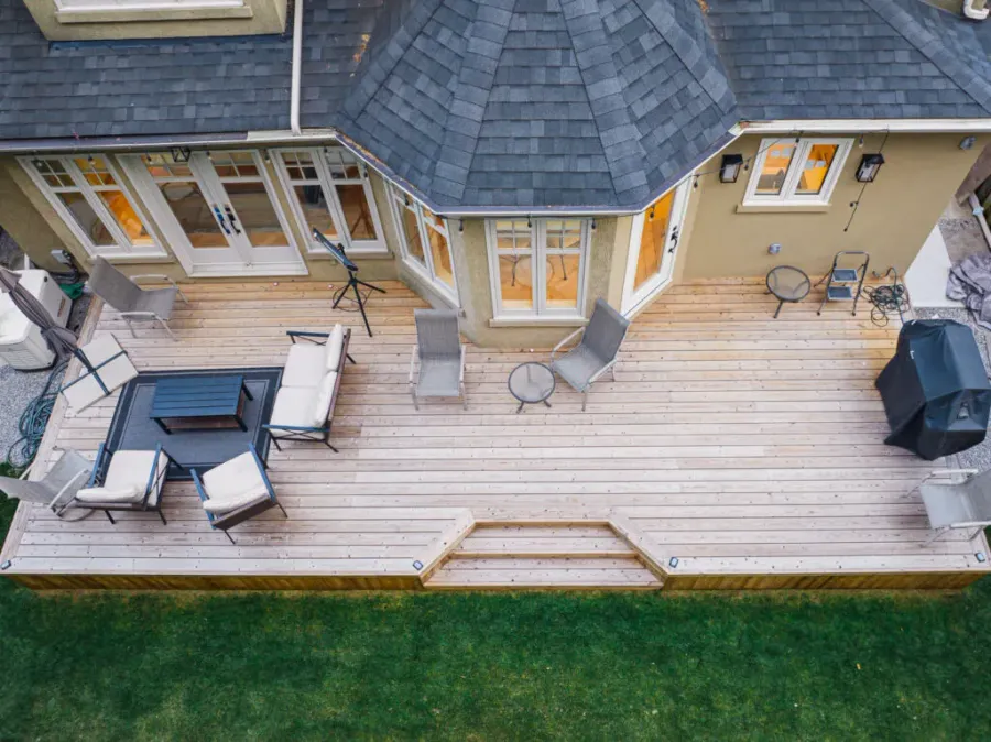Overhead view of a wood deck with angled steps, seating and a garden edge